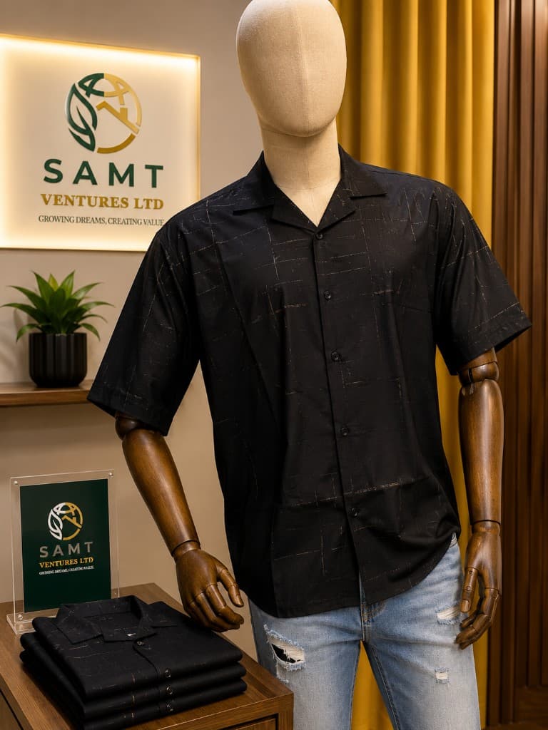 SAMT metallic grid patterned black camp shirt on mannequin beside folded inventory and brand plaque